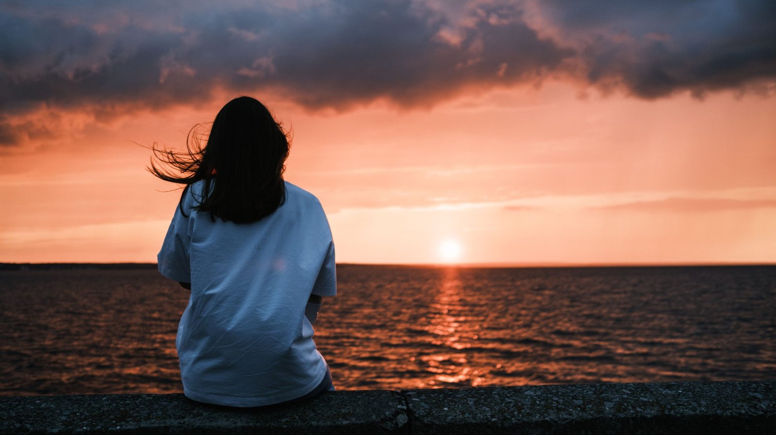About Woman watching sunset at the beach
