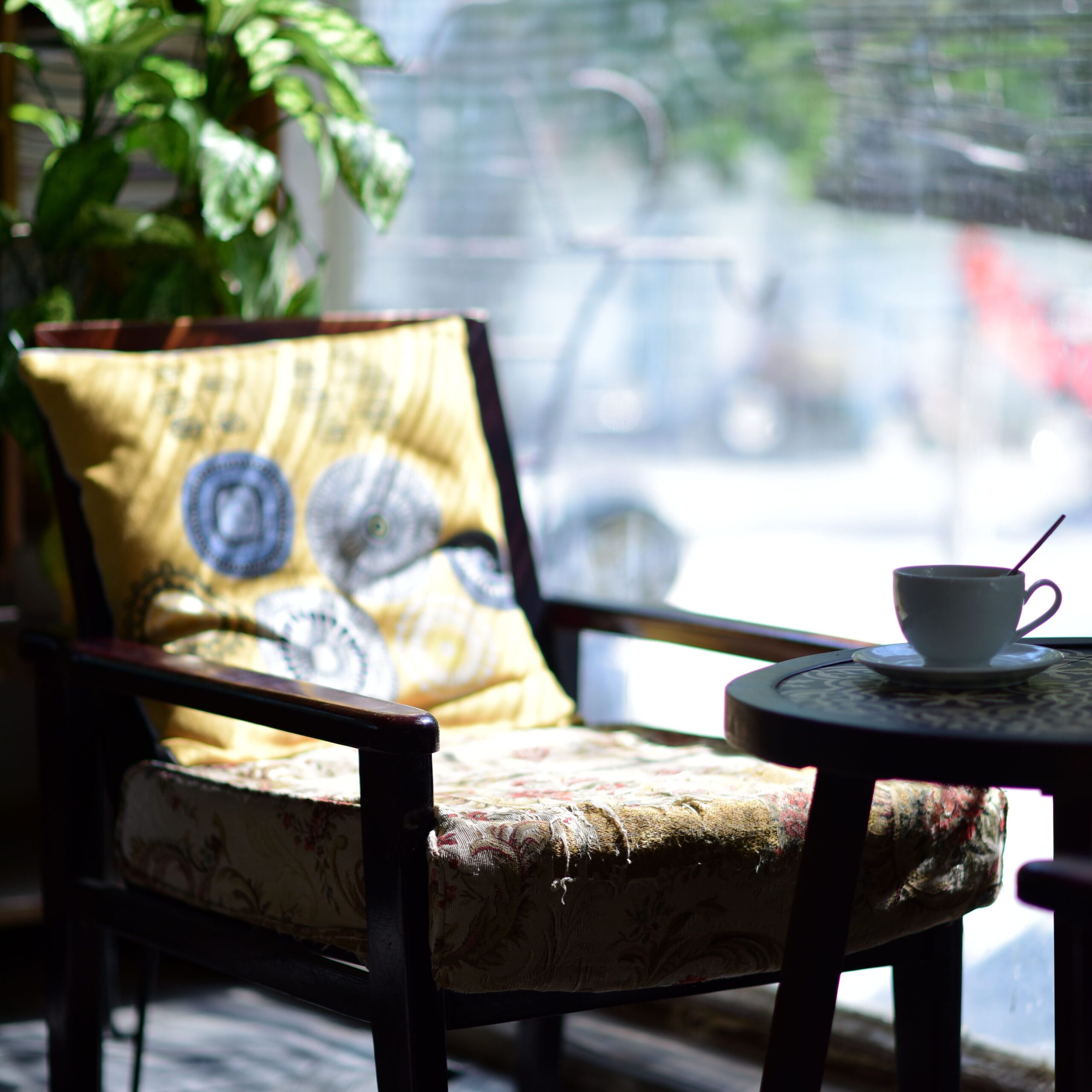 Home Inviting cafe scene with a cushioned chair and coffee cup by the window. Perfect for relaxation shots.