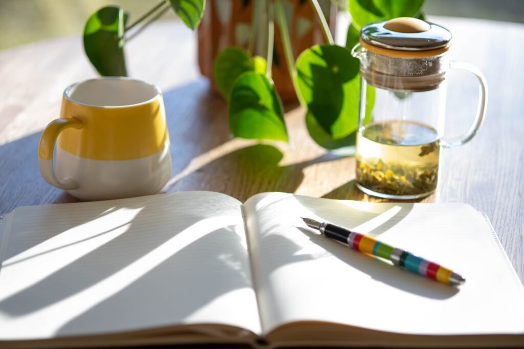 About Sunlit table with journal, plant, and tea